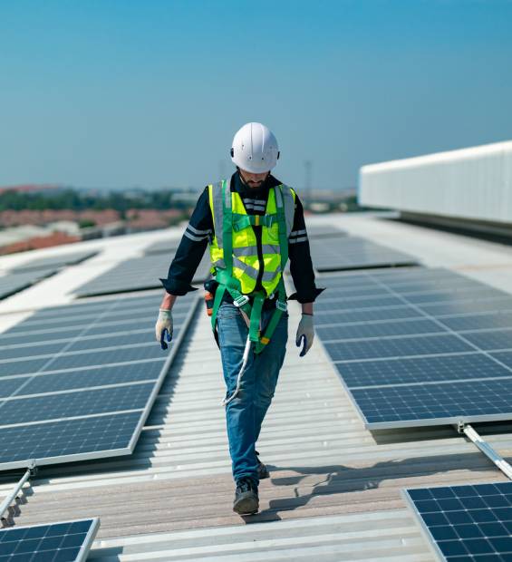 engineers installing solar panels on roof. Male engineers walking along rows of photovoltaic panels